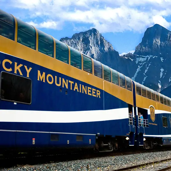 Rocky Mountaineer train in front of mountains 
